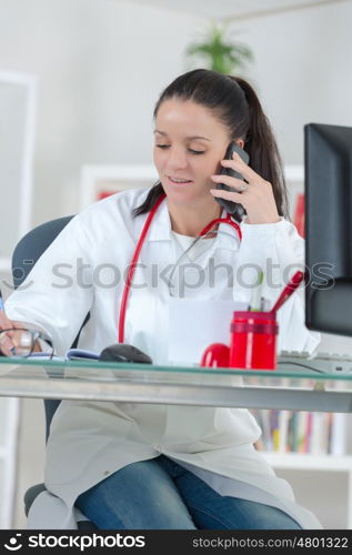 portrait of happy smiling young doctor with cellphone