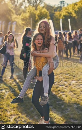 Portrait of happy smiling young girls with colorful paints on faces and clothes. Two friends spending time on holi color festival