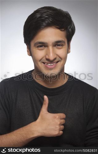 Portrait of happy smiling Young man gesturing thumbs up