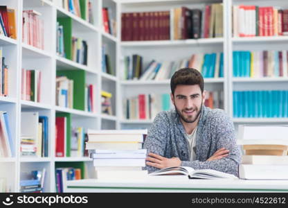 Portrait of happy student while reading book in school library. Study lessons for exam. Hard worker and persistance concept.