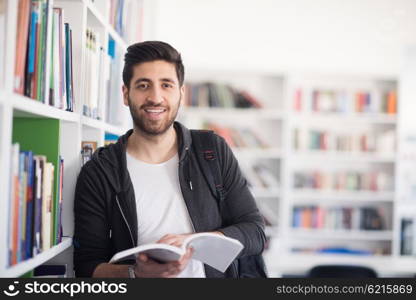 Portrait of happy student while reading book in school library. Study lessons for exam. Hard worker and persistance concept.