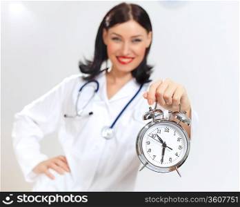 Portrait of happy successful young female doctor holding clocks