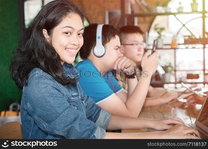 Portrait of happy teenage Asian girl with friends studying, group of happy teenage students with notebooks learning at campus yard, education, high school and people concept