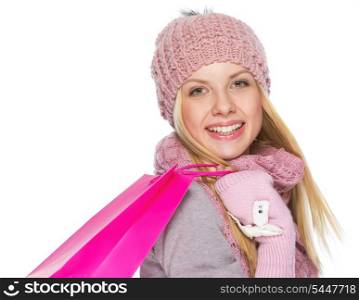 Portrait of happy teenager girl in winter hat and scarf with shopping bag