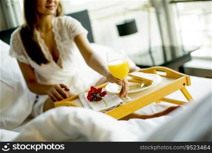 Portrait of happy woman eating breakfast in bed, smiling and healthy