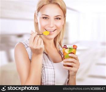 Portrait of happy woman eating tasty fruit salad at home, healthy nutrition, dieting snack, enjoying sweet organic food