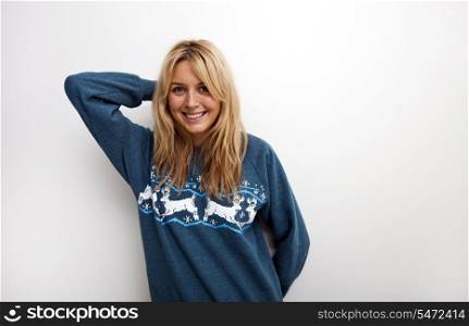 Portrait of happy woman in sweater against white background