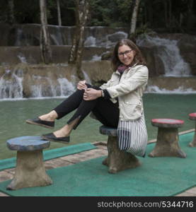 Portrait of happy woman posing near Tad Sae Waterfall, Luang Prabang, Laos