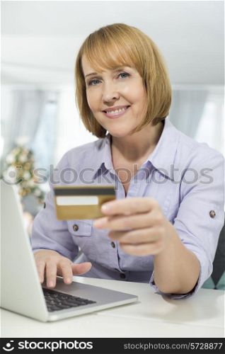 Portrait of happy woman shopping online at home during Christmas