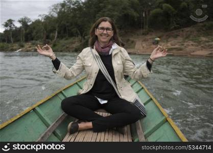 Portrait of happy woman sitting on boat in Nam Khan river, Luang Prabang, Laos