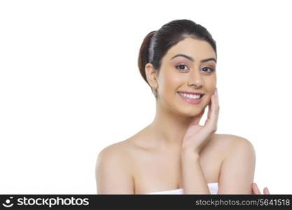 Portrait of happy woman touching cheek over white background