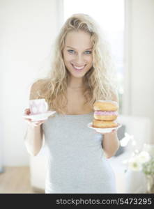 Portrait of happy woman with tea and donut in house