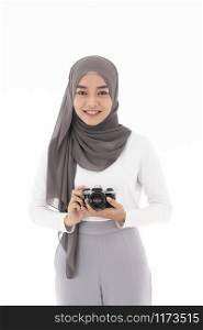 Portrait of happy young adult asian muslim female tourist and photographer holding a camera and smiling. Studio shot of woman isolated on white background