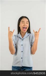Portrait of Happy young asian woman in blue shirt doing rock symbol with hands up isolated on white background. Heavy music and lifestyle concept.