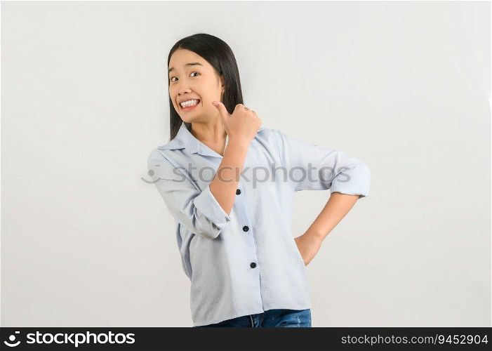 Portrait of Happy young asian woman in blue shirt showing thumb up isolated on white background. Expression and lifestyle concept.