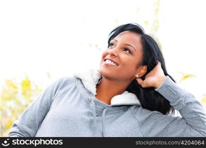 Portrait of happy young black woman looking up outdoors in fall