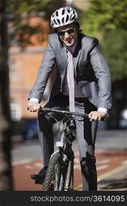 Portrait of happy young businessman riding bicycle
