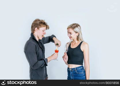 Portrait of happy young couple drinking wine in studio