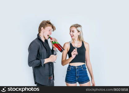 Portrait of happy young couple drinking wine in studio