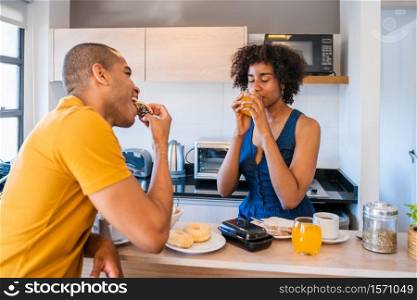 Portrait of happy young couple having breakfast together at home. Relationship and lifestyle concept.