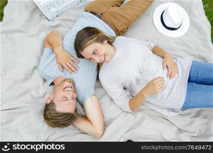 portrait of happy young couple laying on blanket