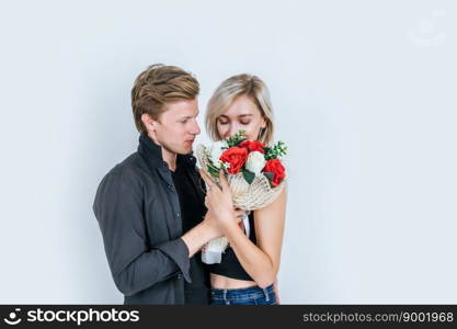 Portrait of happy young couple love together with flower in studio