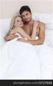 Portrait of happy young couple spending quality time in bed