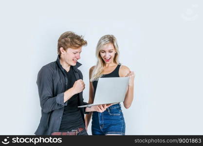 Portrait of happy young couple using laptop computer in studio