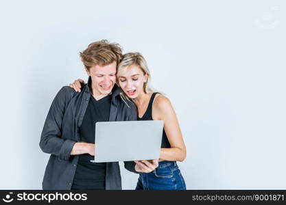 Portrait of happy young couple using laptop computer in studio