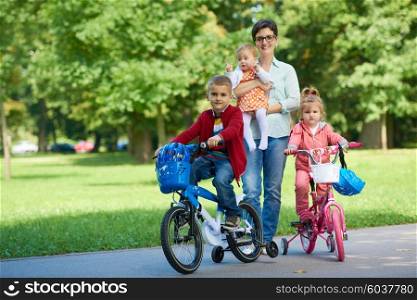 portrait of happy young family, mother and kids have fun in park