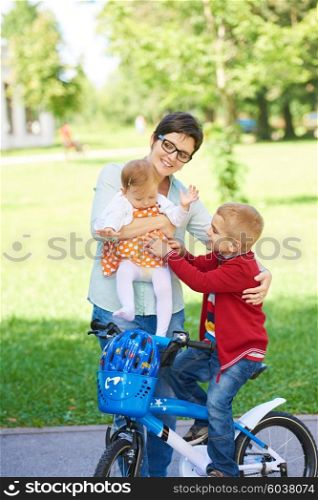 portrait of happy young family, mother and kids have fun in park