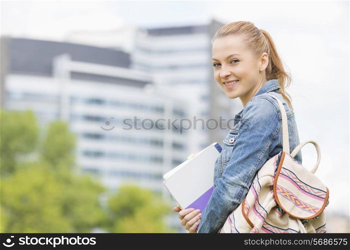 Portrait of happy young female student at college campus
