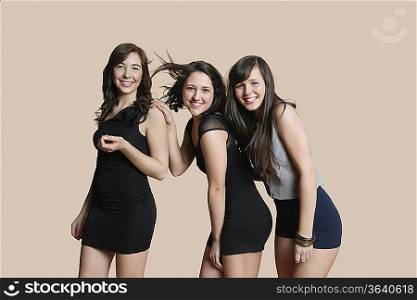 Portrait of happy young friends posing over colored background