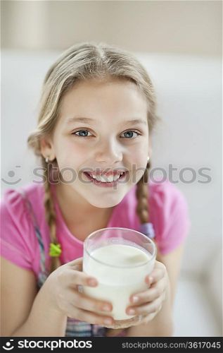 Portrait of happy young girl drinking milk