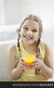 Portrait of happy young girl drinking orange juice