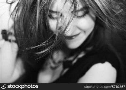Portrait of happy young girl with hair fluttering in the wind
