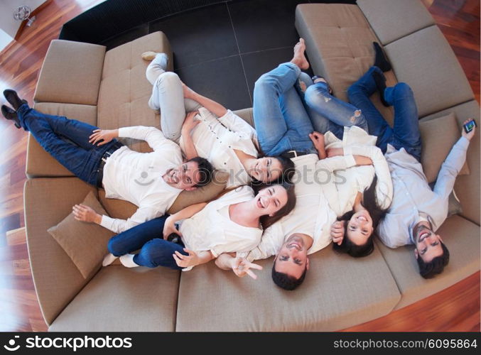 portrait of happy young group of friends get releax and have fun at modern home interior, top view