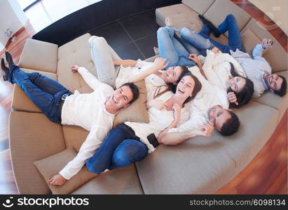 portrait of happy young group of friends get releax and have fun at modern home interior, top view