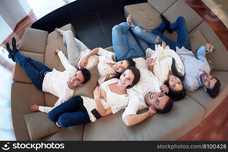 portrait of happy young group of friends get releax and have fun at modern home interior, top view