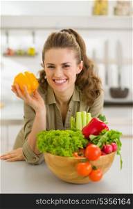 Portrait of happy young housewife with plate of fresh vegetables