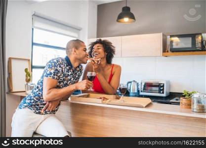 Portrait of happy young latin couple enjoying and having dinner at new home. Lifestyle and relationship concept.