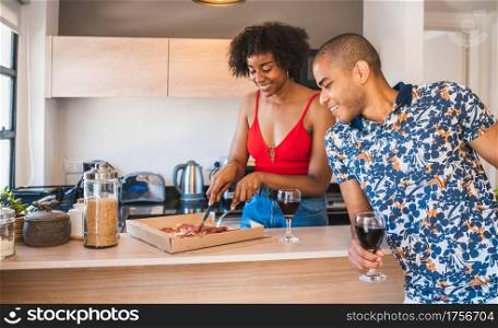 Portrait of happy young latin couple enjoying and having dinner at new home. Lifestyle and relationship concept.