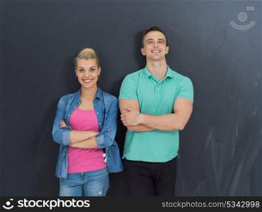 portrait of happy young loving couple in front of gray chalkboard