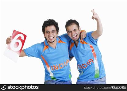 Portrait of happy young male friends in jerseys cheering over white background