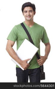Portrait of happy young male student holding laptop