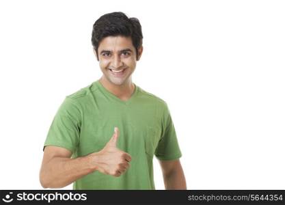 Portrait of happy young man giving you thumbs up on white background