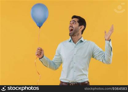 Portrait of happy young man holding balloon in hand and gesturing with palm