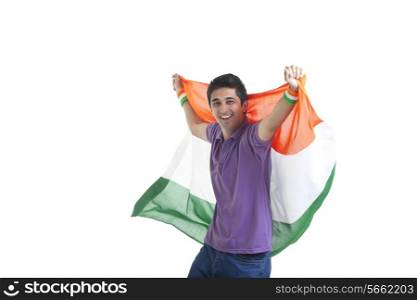 Portrait of happy young man in casual wear holding Indian flag over white background