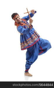 Portrait of happy young man in traditional wear performing Dandiya Rass over white background