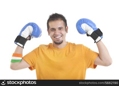 Portrait of happy young man wearing boxing gloves over white background